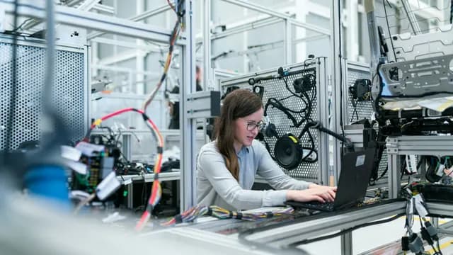 Engineer monitors specialized laboratory equipment from a workstation in an industrial research lab
